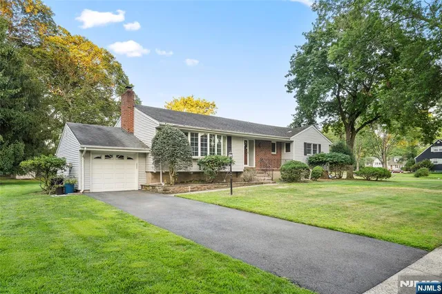 a front view of a house with a garden and patio