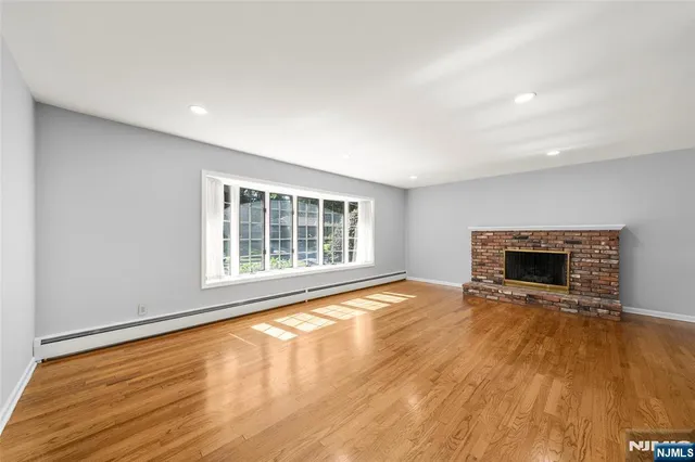 a view of an empty room with a fireplace and a window
