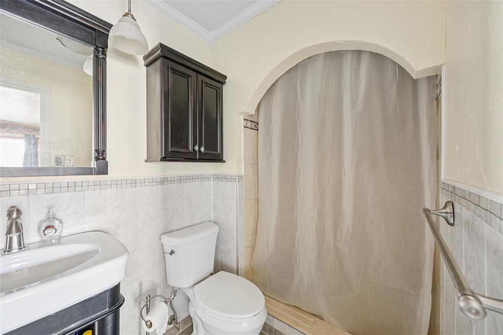 3113 Ridgemoor Drive Garland, TX 75044 - Photo 14 of 30 a white toilet sitting next to a bathroom sink