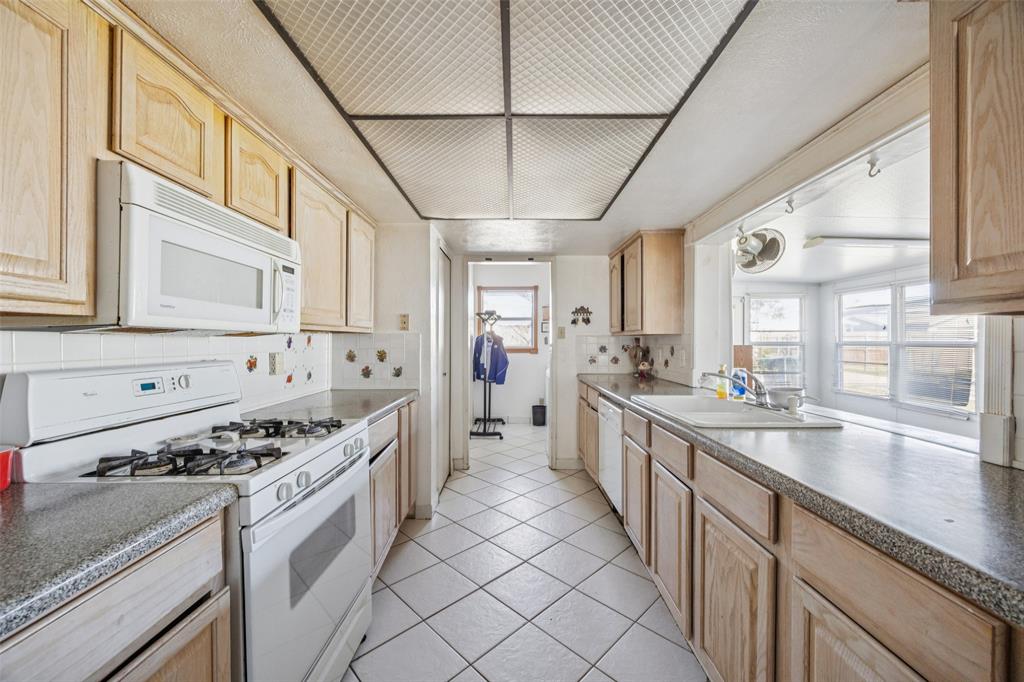 3113 Ridgemoor Drive Garland, TX 75044 - Photo 18 of 30 a large kitchen with stainless steel appliances granite countertop a lot of counter space and a sink