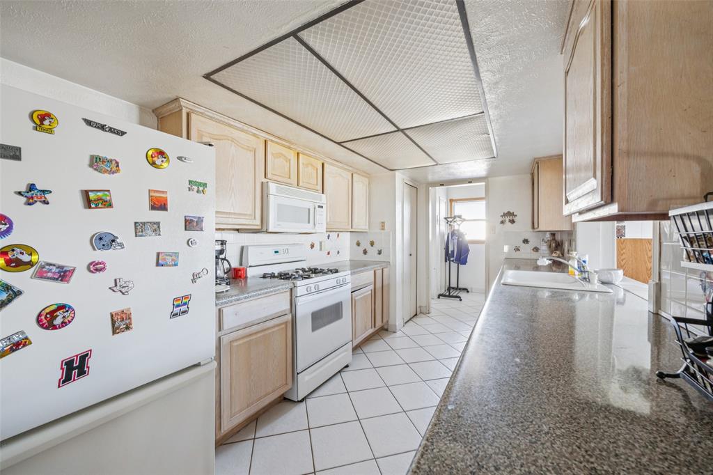 3113 Ridgemoor Drive Garland, TX 75044 - Photo 20 of 30 a kitchen with stainless steel appliances a stove a sink and a refrigerator