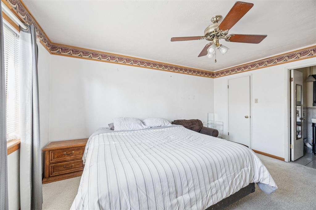 3113 Ridgemoor Drive Garland, TX 75044 - Photo 25 of 30 a bedroom with a bed and a chandelier