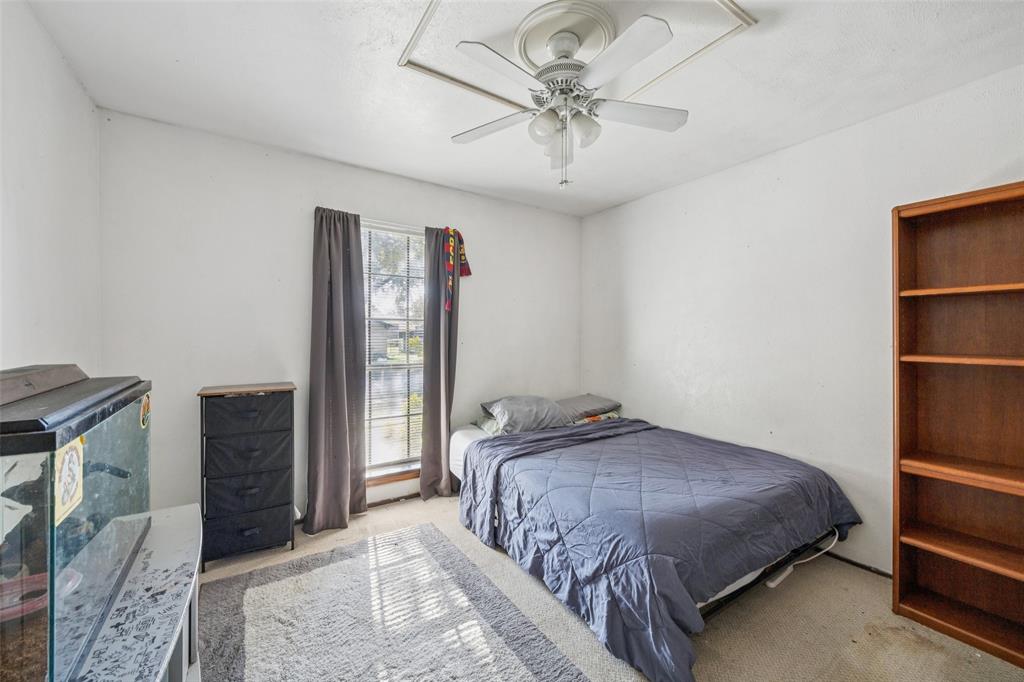 3113 Ridgemoor Drive Garland, TX 75044 - Photo 10 of 30 a bedroom with a large bed and a chandelier