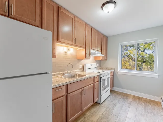 a kitchen with a sink cabinets stainless steel appliances and a window
