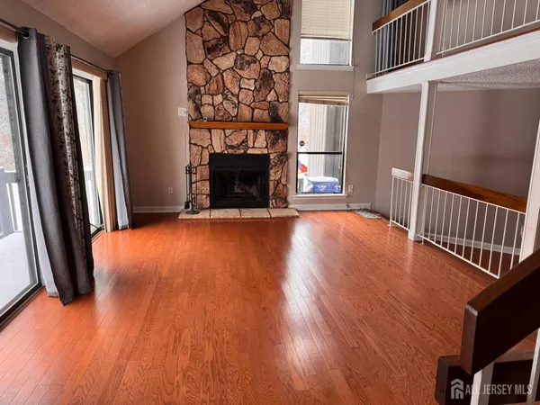 a view of empty room with wooden floor and fireplace