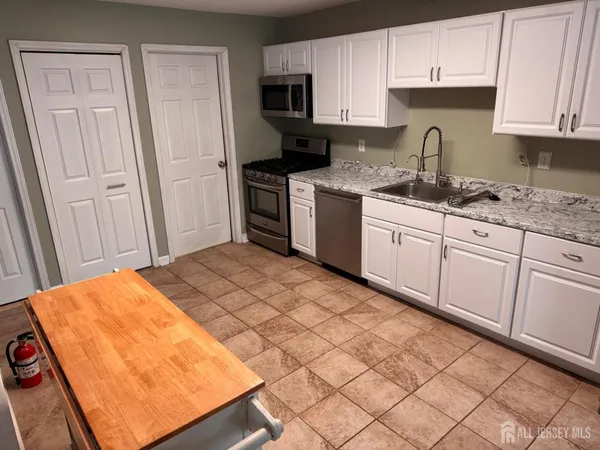 a kitchen with stainless steel appliances granite countertop a refrigerator sink and cabinets
