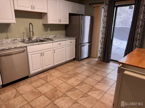 a kitchen with stainless steel appliances a refrigerator sink and cabinets