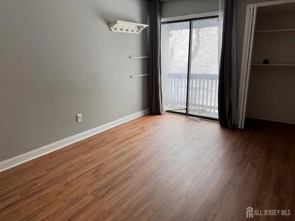 a view of a room with wooden floor and window