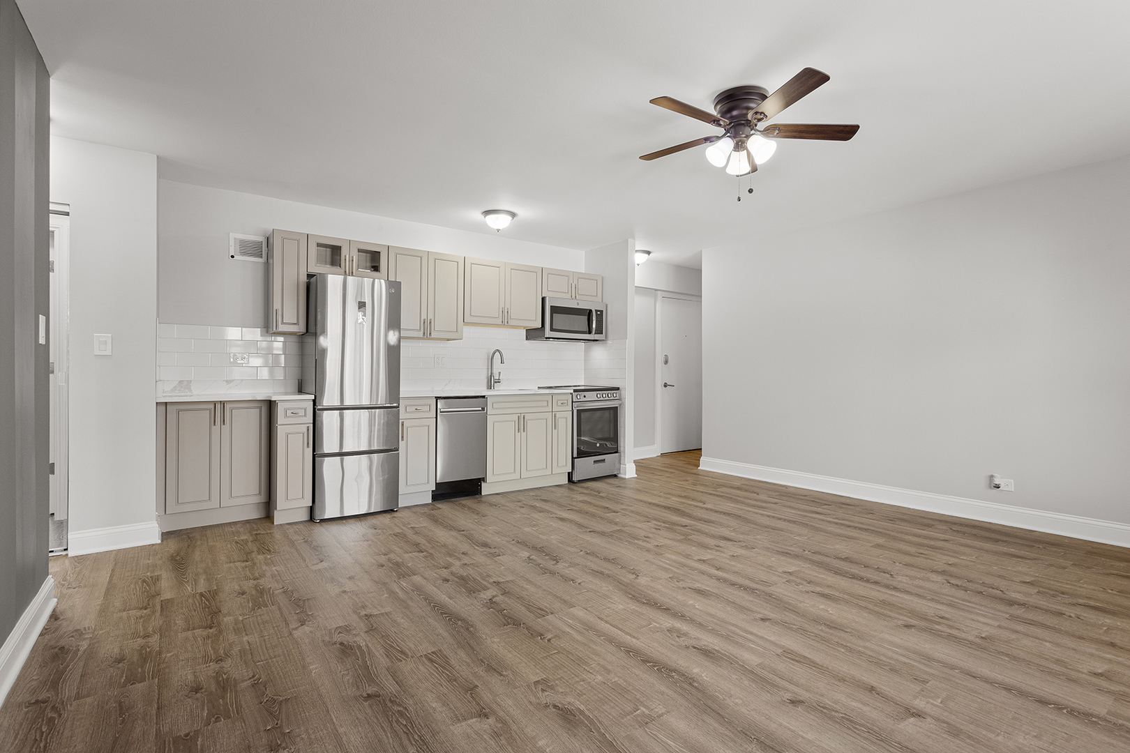7710 North Sheridan Road, Unit 204 Chicago, IL 60626 - Photo 3 of 13 a view of a kitchen with wooden floor electronic appliances and a ceiling fan