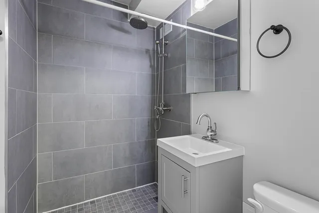 a bathroom with a granite countertop sink toilet and shower
