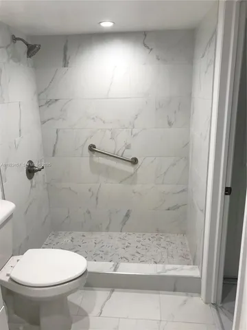 a bathroom with a toilet and a shower