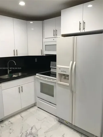 a kitchen with a white cabinets and white appliances
