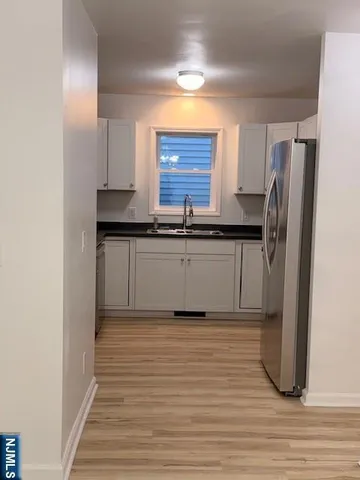 a kitchen with stainless steel appliances granite countertop a refrigerator and a sink