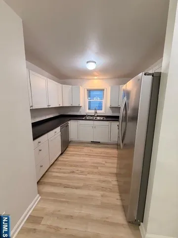 a large kitchen with cabinets stainless steel appliances a sink and a window