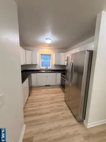 a large kitchen with a refrigerator a stove top oven a sink and dishwasher