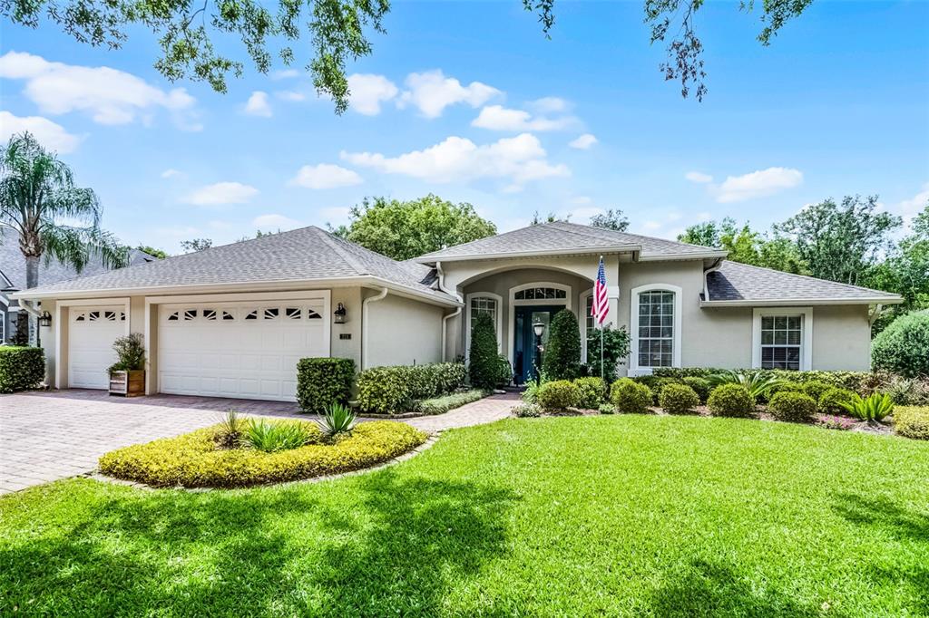 a view of a house with a yard and potted plants