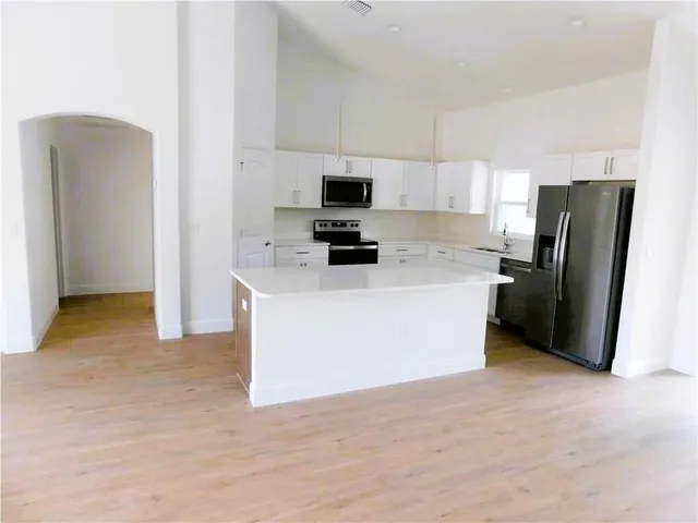 a kitchen with stainless steel appliances a refrigerator sink and microwave