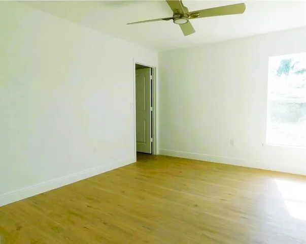 an empty room with a ceiling fan and carpet