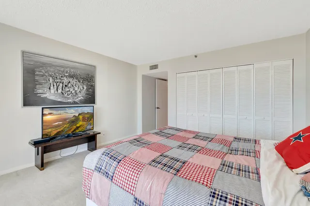 a bedroom with a large bed and a flat tv screen next to a window