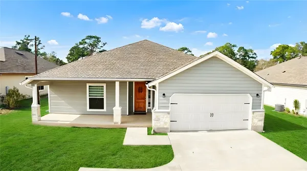 a front view of house with a garden