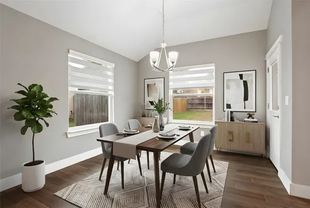 an empty room with wooden floor chandelier and windows