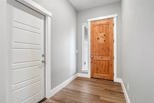 an empty room with wooden floor cabinet and door