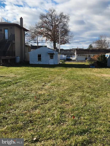 a white house covered with tall trees