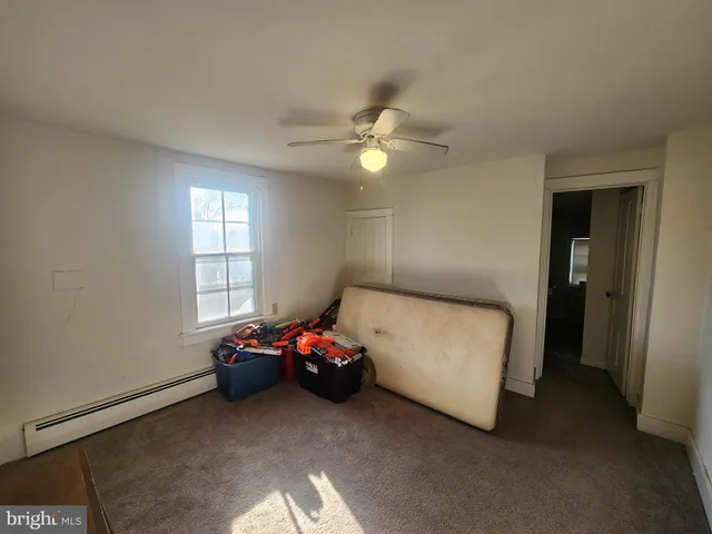 a bedroom with furniture a flat screen tv and a window