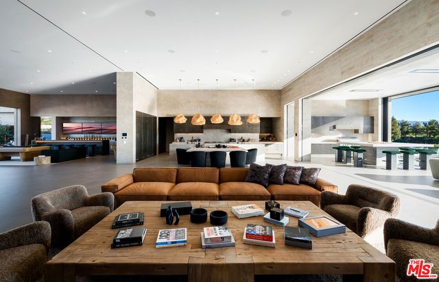 a living room with furniture kitchen view and a large window