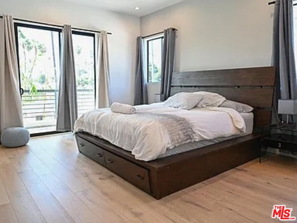1410 Coronado Terrace Los Angeles, CA 90026 - Photo 11 of 27 a bedroom with a bed and wooden floor