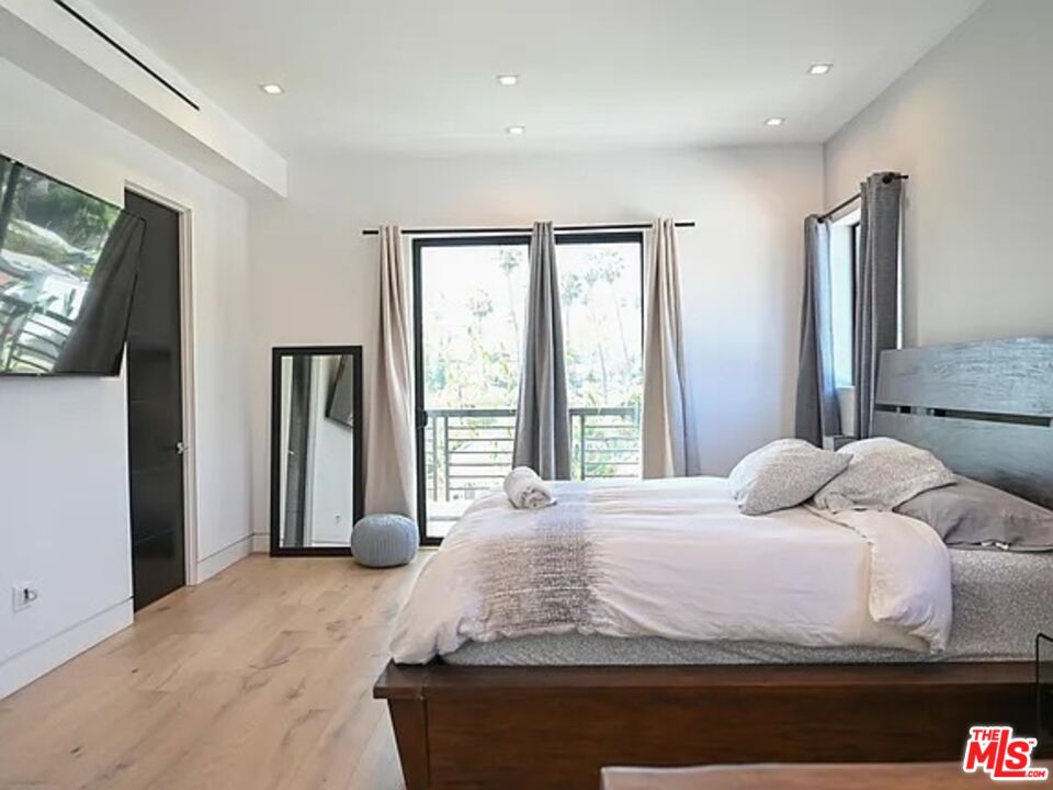 1410 Coronado Terrace Los Angeles, CA 90026 - Photo 12 of 27 a bedroom with a large bed and a flat screen tv