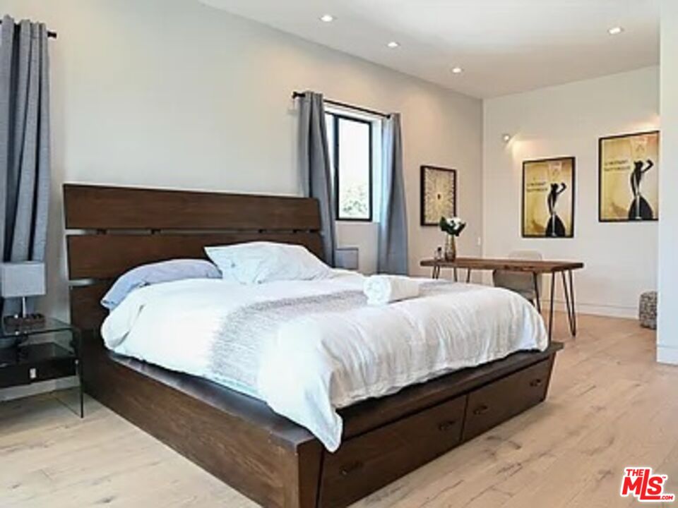 1410 Coronado Terrace Los Angeles, CA 90026 - Photo 13 of 27 a large bed sitting in a bedroom and mirror