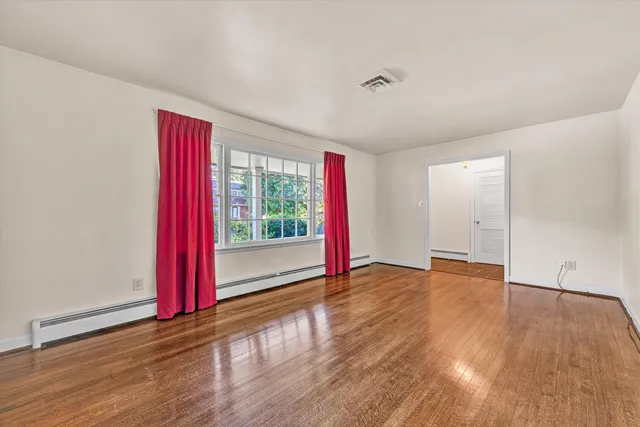 a view of a room with wooden floor and a window