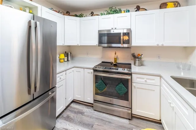 a kitchen with stainless steel appliances white cabinets and a refrigerator