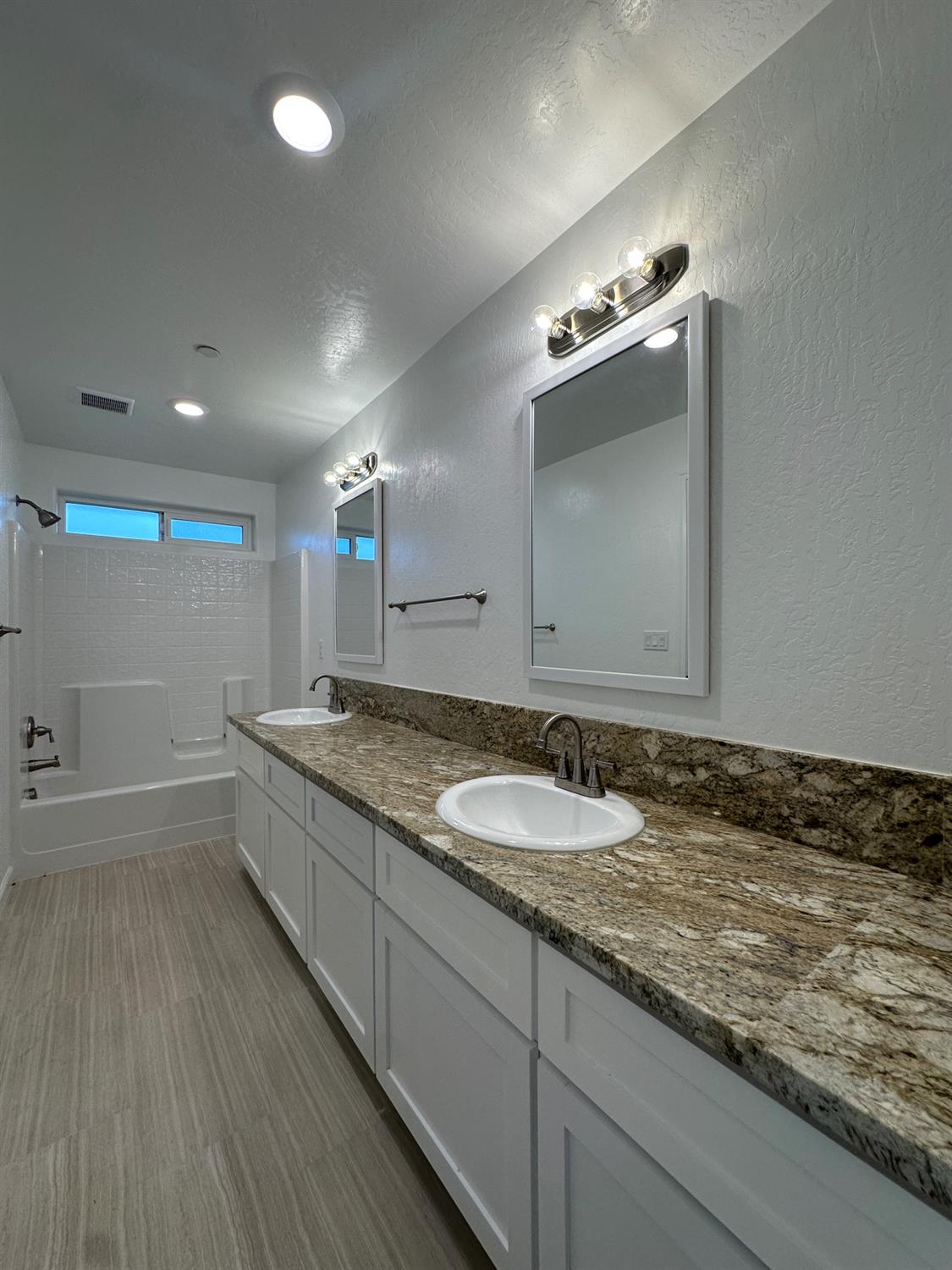20568 Road 31 Madera, CA 93638 - Photo 19 of 24 a bathroom with a granite countertop sink a large mirror and shower