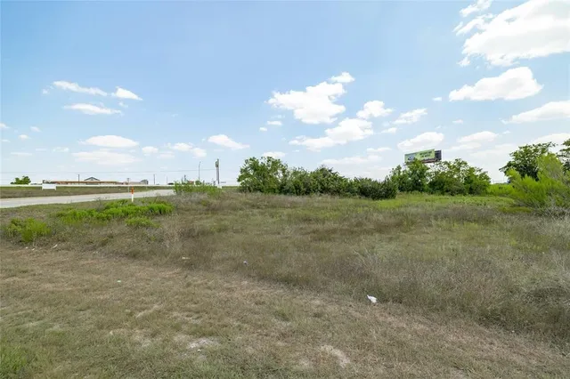 a view of a field with trees in the background