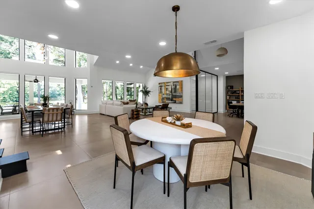 a view of a dining room and livingroom with furniture wooden floor a chandelier