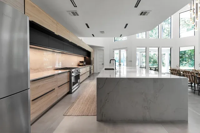 a large kitchen with stainless steel appliances kitchen island a large counter top