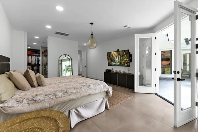 a spacious bedroom with a bed and a dresser