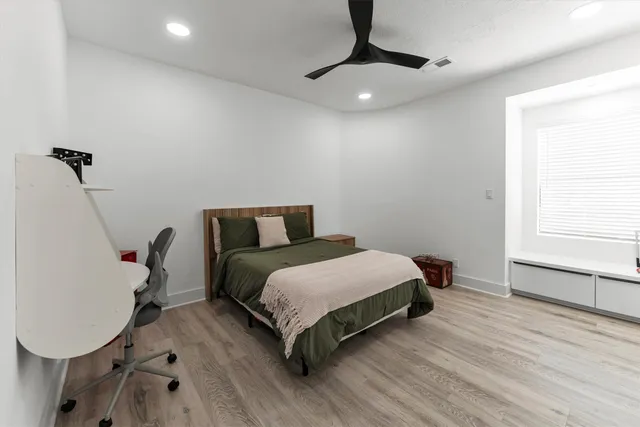 a bedroom with a bed a desk and chair