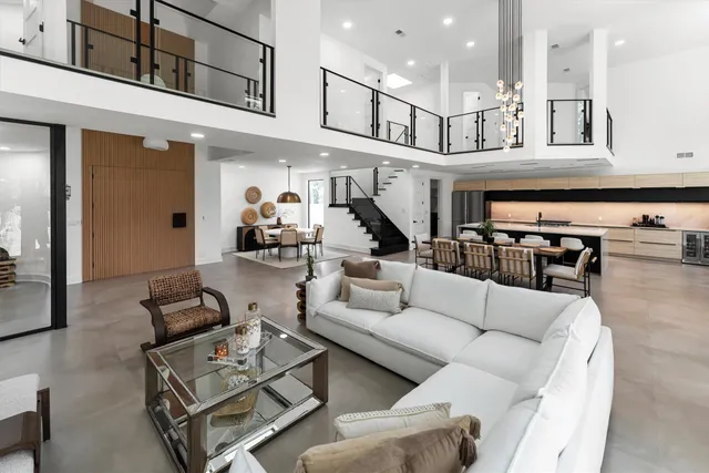 a living room with furniture kitchen view and a chandelier
