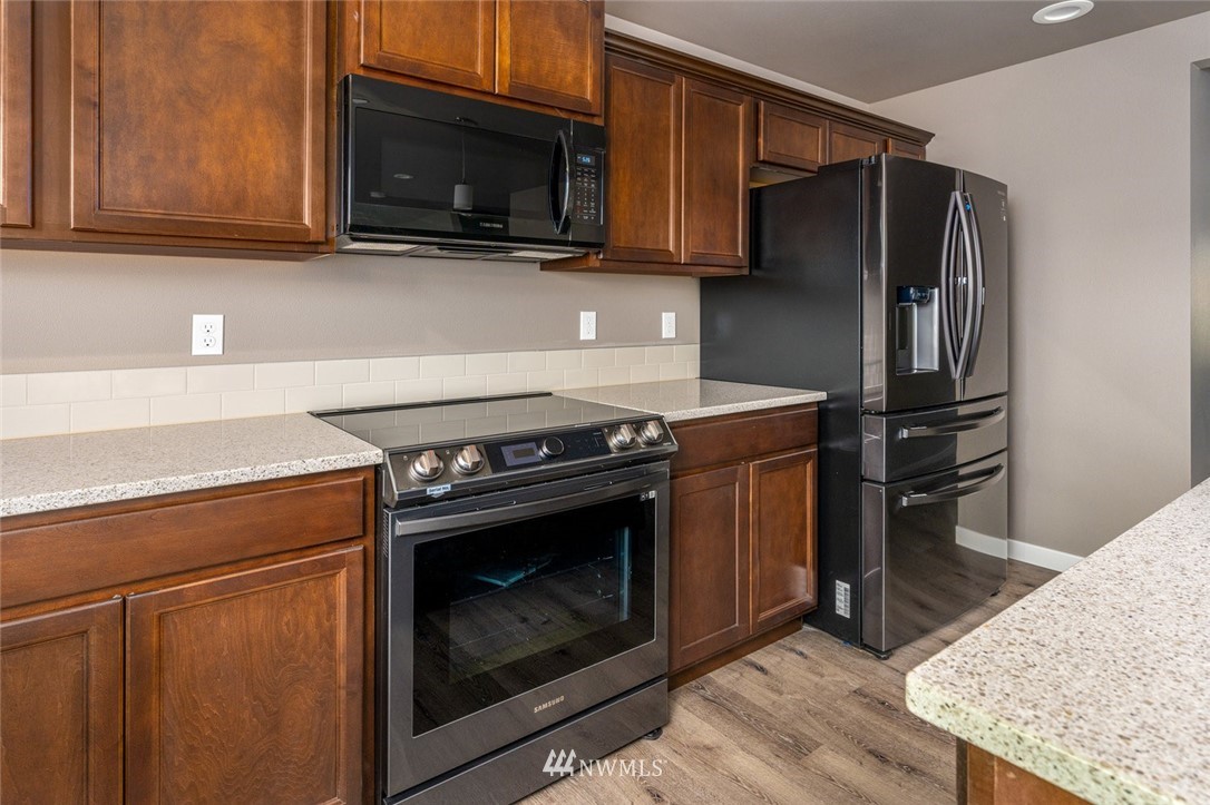 10503 Angeline Road East Bonney Lake, WA 98391 - Photo 11 of 38 a kitchen with a stove microwave and refrigerator