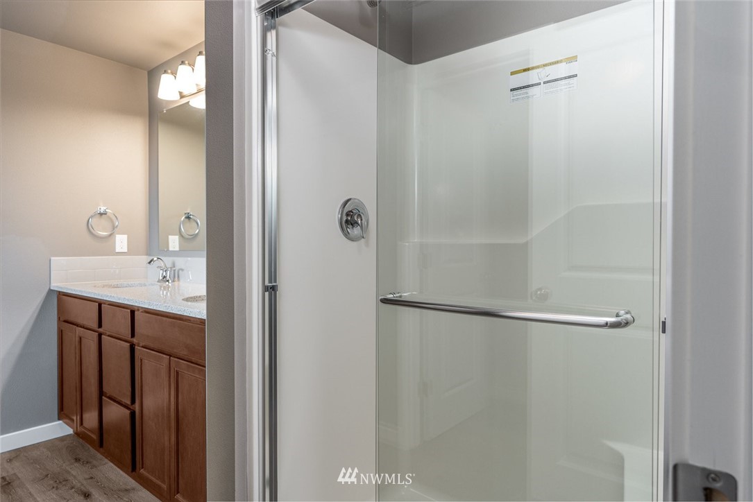 10503 Angeline Road East Bonney Lake, WA 98391 - Photo 22 of 38 a bathroom with a shower sink vanity and mirror