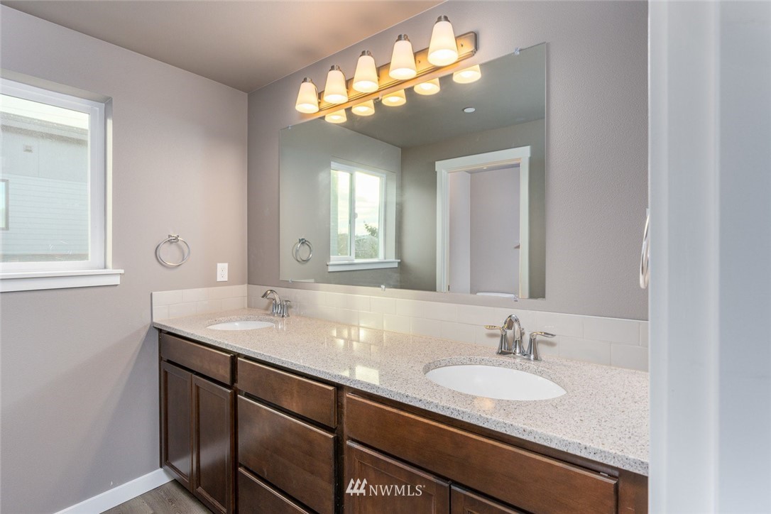 10503 Angeline Road East Bonney Lake, WA 98391 - Photo 30 of 38 a bathroom with a granite countertop double vanity and a mirror
