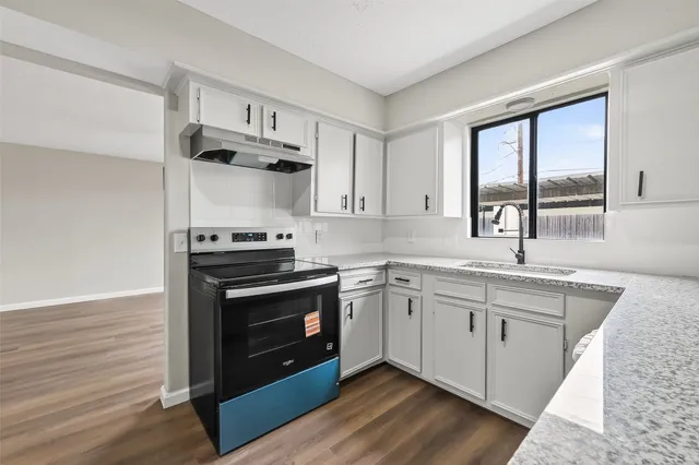 a kitchen with a sink cabinets and wooden floor