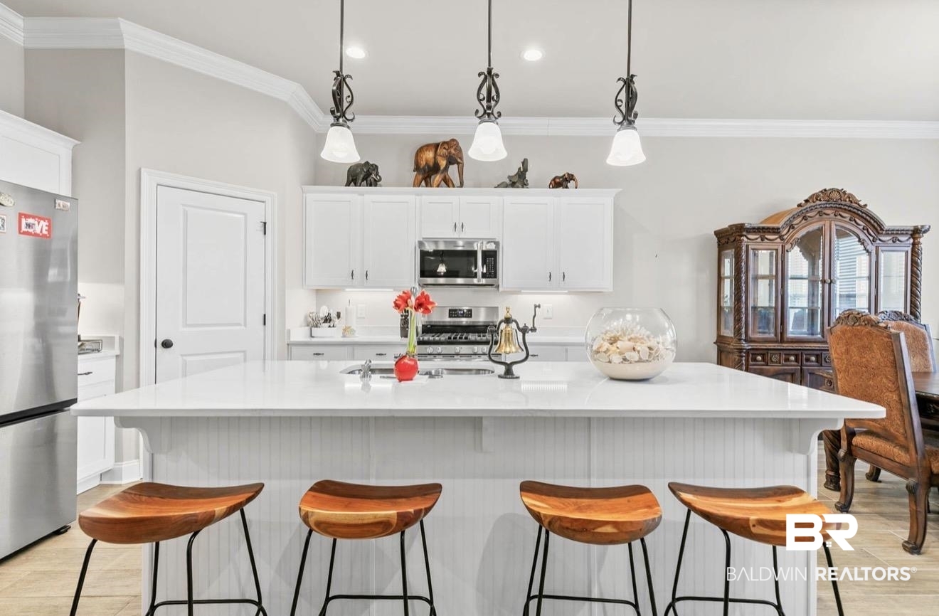 10126 Chipper Lane Foley, AL 36535 - Photo 6 of 30 Kitchen with white cabinetry, decorative light fixtures, stainless steel appliances, wood finish floors, and ornamental molding