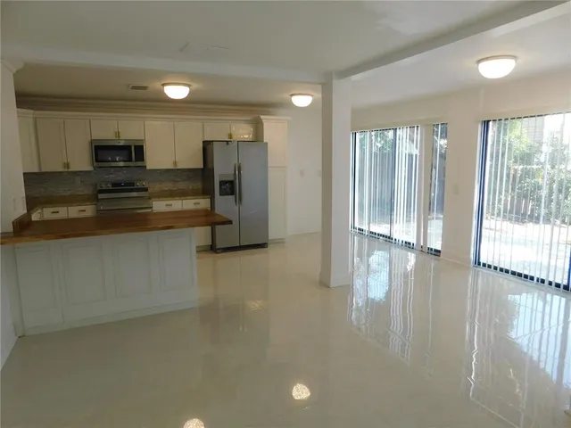 a kitchen with stainless steel appliances a refrigerator and a stove top oven