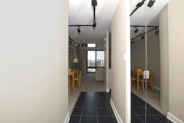 1221 North Dearborn Parkway, Unit 1601N Chicago, IL 60610 - Photo 3 of 21 a view of a hallway with wooden floor and a bathroom