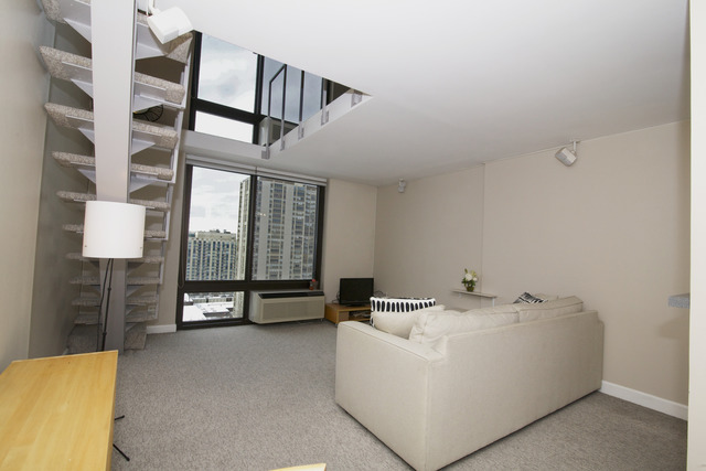 1221 North Dearborn Parkway, Unit 1601N Chicago, IL 60610 - Photo 7 of 21 a living room with furniture and a floor to ceiling window