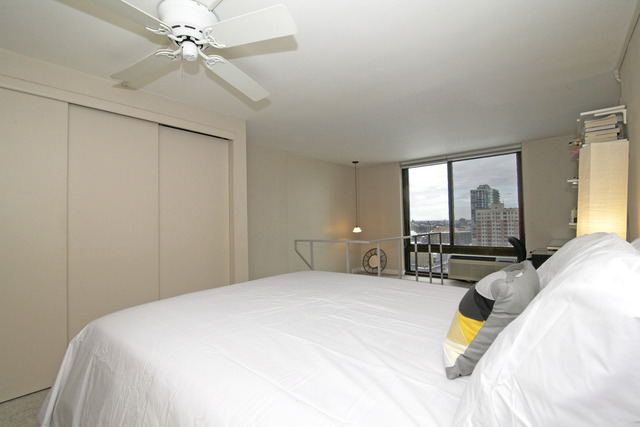 1221 North Dearborn Parkway, Unit 1601N Chicago, IL 60610 - Photo 10 of 21 a bedroom with a bed a chandelier and large window